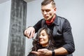 Beauty, hairstyle and people concept - happy young woman and hairdresser cutting hair tips at salon. Royalty Free Stock Photo