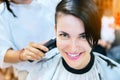 Beauty, hairstyle, treatment and hair care concept - young woman and hairdresser cutting her hair at hairdressing salon. Royalty Free Stock Photo