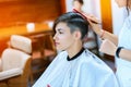 Beauty, hairstyle, treatment, hair care concept, young woman and hairdresser cutting hair at hairdressing salon. Hairdresser cutts Royalty Free Stock Photo