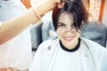 Beauty, hairstyle, treatment, hair care concept, young woman and hairdresser cutting hair at hairdressing salon. Hairdresser cuts Royalty Free Stock Photo