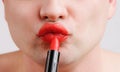 Beauty handsome artist man paint his lips with red lipstick