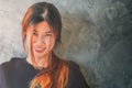 Beauty Happy Asian woman smiling portrait infront of a gray cement wall Loft style copy space