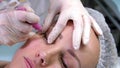 Professional stylist make-up artist makes eye makeup model or lengthening female lashes. Eyelash extension procedure.