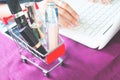 Beauty items and cosmetics in shopping trolley with woman using Royalty Free Stock Photo