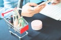 Beauty items and woman essentials in shopping cart with woman us Royalty Free Stock Photo