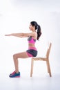 Beauty lady iis wearing exercise suit,sitting on wooden chair,raise hands up in the air,sit upright,basic pattern for exercise