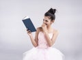 The beauty lady is wearing pink ballet dress,reading book with smile and happy face Royalty Free Stock Photo