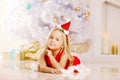 Beauty little Santa girl near the Christmas tree. Happy girl wi Royalty Free Stock Photo