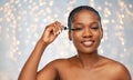 Beautiful african american woman applying mascara Royalty Free Stock Photo