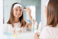 teenage girl applying face mask at bathroom Royalty Free Stock Photo