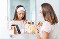 teenage girl applying lip gloss at bathroom Royalty Free Stock Photo