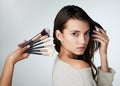 Beauty, makeup brush and face of a woman in studio with a natural glow. Portrait of a female person on a grey background Royalty Free Stock Photo