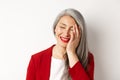 Beauty and makeup concept. Close up of beautiful asian mature woman, laughing and touching face, smiling happy, standing Royalty Free Stock Photo