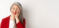 Beauty and makeup concept. Close up of beautiful asian mature woman, laughing and touching face, smiling happy, standing Royalty Free Stock Photo