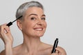 Beauty And Makeup Concept. Portrait Of Smiling Beautiful Middle-Aged Woman Applying Maskara Royalty Free Stock Photo