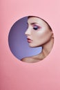 Beauty makeup cosmetics nature fashion woman in a round hole circle in pink paper, copy space advertising. Professional makeup Royalty Free Stock Photo