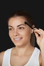 Beauty makeup. Eyebrows Care. Beautiful woman shaping brows with comb. Correcting and contouring eyebrows Royalty Free Stock Photo