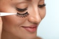 Beauty Makeup. Woman Applying Black False Eyelashes With Tweezer