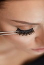 Beauty Makeup. Woman Applying Black False Eyelashes With Tweezer Royalty Free Stock Photo