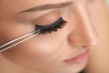 Beauty Makeup. Woman Applying Black False Eyelashes With Tweezer Royalty Free Stock Photo