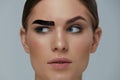 Beauty makeup. Woman coloring eyebrow with brow gel tint Royalty Free Stock Photo