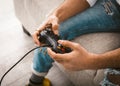 Beauty male hands using joystick. Gamer uses wired gamepad playing computer games. Close up shot. Home entertainment Royalty Free Stock Photo