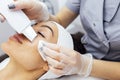 Beauty master makes ultrasonic facial peeling to her client