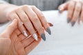 Beauty master manicurist do manicure to client. Closeup acrylic artificial nails painted in gray and marble design during manicure