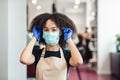 Beauty master putting on protective medical mask before work in salon