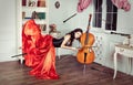 Beauty in mid-air. Full length studio shot of attractive young woman in orange dress hovering in air and playing the Royalty Free Stock Photo