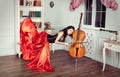 Beauty in mid-air. Full length studio shot of attractive young woman in orange dress hovering in air and playing the Royalty Free Stock Photo