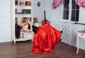 Beauty in mid-air. Full length studio shot of attractive young woman in orange dress hovering in air and playing the Royalty Free Stock Photo