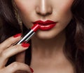 Beauty Model applying Red Lipstick. Perfect Lips Make up and Nail Polish Close up. Glamour Face Makeup Cosmetics Royalty Free Stock Photo