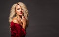 Beauty Model with Blond Curly Hair and Red Lipstick. Fashion Woman with Glamour Make up and Blonde Wavy Hairstyle over Black. Royalty Free Stock Photo