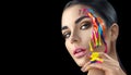 Beauty model girl with colorful paint on her face. Portrait of beautiful woman with flowing liquid paint Royalty Free Stock Photo