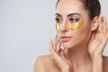 Beauty model girl face with healthy fresh skin. Woman with under eye collagen gold pads. Royalty Free Stock Photo