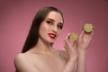 Beauty model girl holding two juicy lime sliced in half in her hands looking sideways. Charming joyful funny lady with