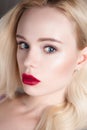 Beauty model girl with perfect make-up red lips and blue eyes looking at camera. Portrait of attractive young woman with blond hai Royalty Free Stock Photo