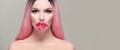 Beauty model girl with pink flower in her mouth. Beautiful spring young romantic woman with pink hair posing