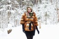 Beauty model girl in winter forest. beautiful young Woman in fashionable Fur Coat and scarf Royalty Free Stock Photo