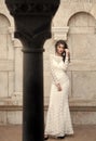Beauty model with glamour look and makeup. Sensual woman pose at column. Woman with long brunette hair. Bride with Royalty Free Stock Photo