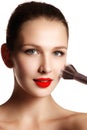 Beauty model with makeup Brush. Bright make-up for brunette woma