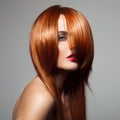 Beauty model with perfect long glossy red hair.