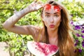 Beauty model with watermelon enjoy her vacation in flower tropical garden. Beautiful woman with red sunglasses Royalty Free Stock Photo