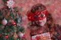 Beauty model woman wearing venetian masquerade carnival mask on light background with red bokeh effect. Celebrating Royalty Free Stock Photo