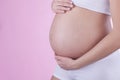 The picture of baby bump isolated on pink background. The happiness of waiting for a new family member. Royalty Free Stock Photo