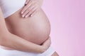 The picture of baby bump isolated on pink background. The happiness of waiting for a new family member. Royalty Free Stock Photo