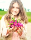 Beauty of nature. Smiling young girl holding meadow clover flowers