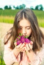 Beauty of nature. Smiling young girl smelling meadow clover flow