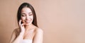 Beauty nude portrait of happy young beautiful asian woman with healthy dark long hair in top bando on beige background, banner Royalty Free Stock Photo
